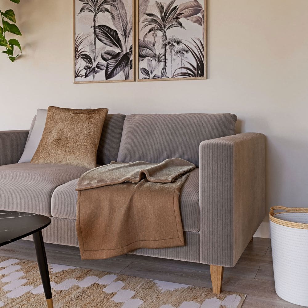 Canapé Holden de Maison du Monde beige avec plaid dans un petit salon